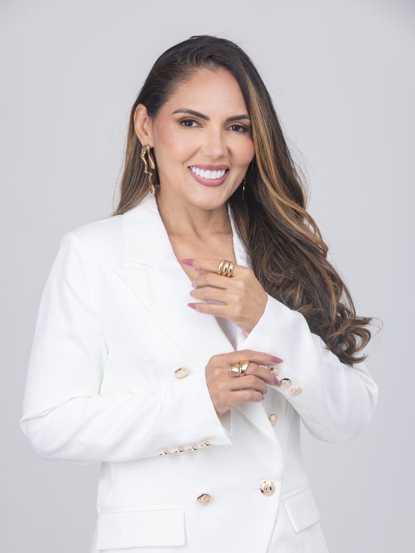 Dra. Patrícia Fonseca sorrindo, de blazer branco